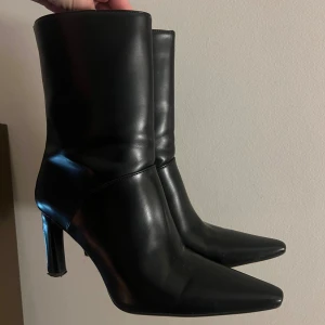 Boots med spetsig tå från H&M - Svarta boots med spetsig tå från H&M. Storlek på skorna är 38. Klacken har en längd på 10 cm, men supersköna att gå i en hel dag. Har dragkedja baktill på skorn. Nypris: 799