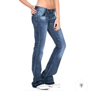 Blå bootcut jeans - Säljer ett par snygga blå bootcut jeans. De har en klassisk femficksdesign och en lätt slitning på låren för en cool look. Perfekta för både vardag och fest!