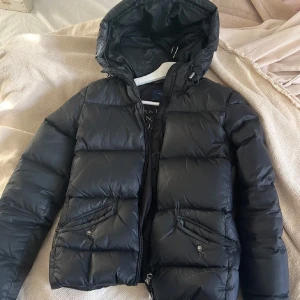 Gant jacka - Svart gant jacka i dun. Köpte den förra vintern och säljer den för att jag köpt en ny vinterjacka, inget fel på den förutom ett litet litet hål som jag kan skicka bild på om det önskas💗obs lånade bilder, om du vill ha fler så kan du skriva🌸