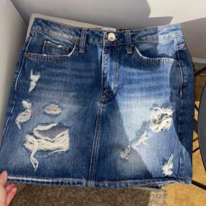 Jeanskjol med fickor/slitningar framtill från Riverisland storlek 8 (34 EU).  Hör av er vid Intresse!  