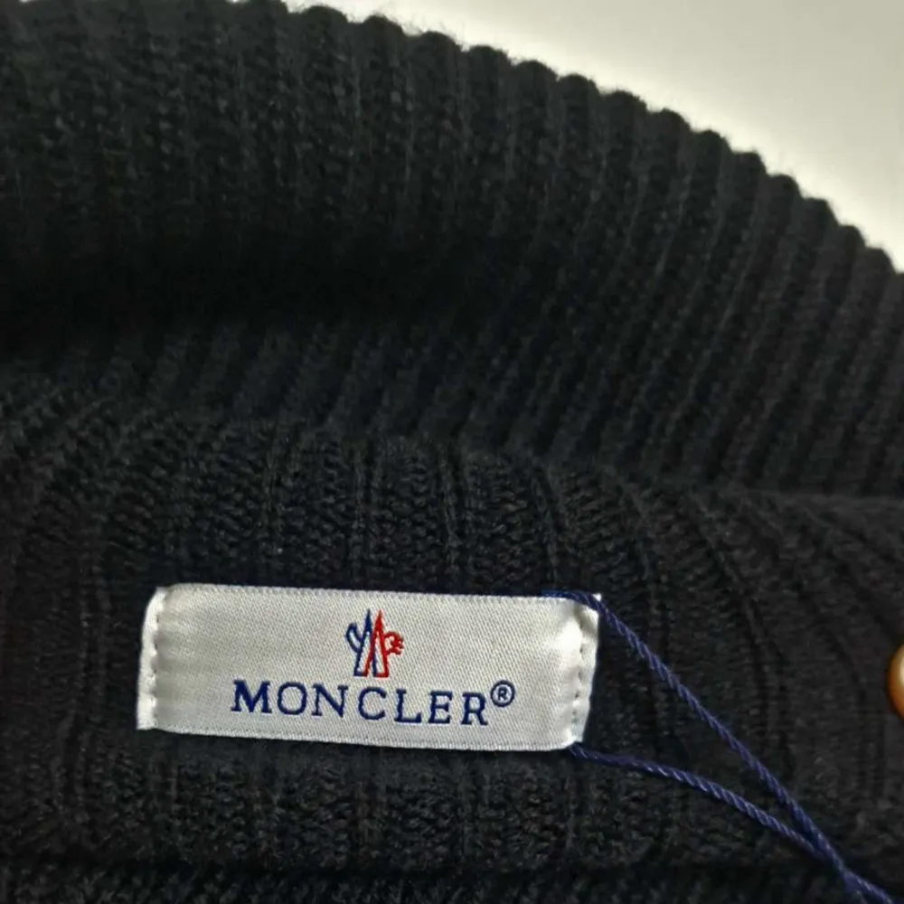 Säljer en snygg svart ribbad mössa från Moncler🔥. Perfekt för att hålla sig varm och stilren under de kallare månaderna🥶. Passar till alla outfits och är ett måste i vintergarderoben!! Size: Fits all!!! Fraktar snabbt📦, kom med frågor och bud!! Köpt är köpt👈👈 . Accessoarer.