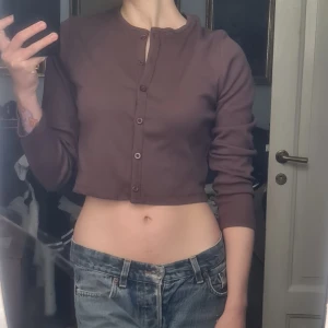 Kofta/topp brun L - 60-talig, kall brun. Fint skick. 97% bomull 3% elastan. Bröstvidd: 44 Längd: 44 Nederkant: 39 Ärmlängd: 57