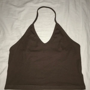 Brun halterneck topp - Snygg brun halterneck topp i ribbat material. Öppen rygg.