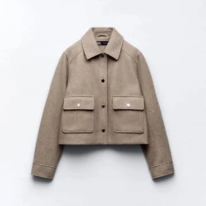 Beige jacka med fickor - Säljer en snygg beige jacka i ull med stora fickor fram och knappar. Den har en klassisk krage och är perfekt för höst och vår. erfekt för en stilren look!