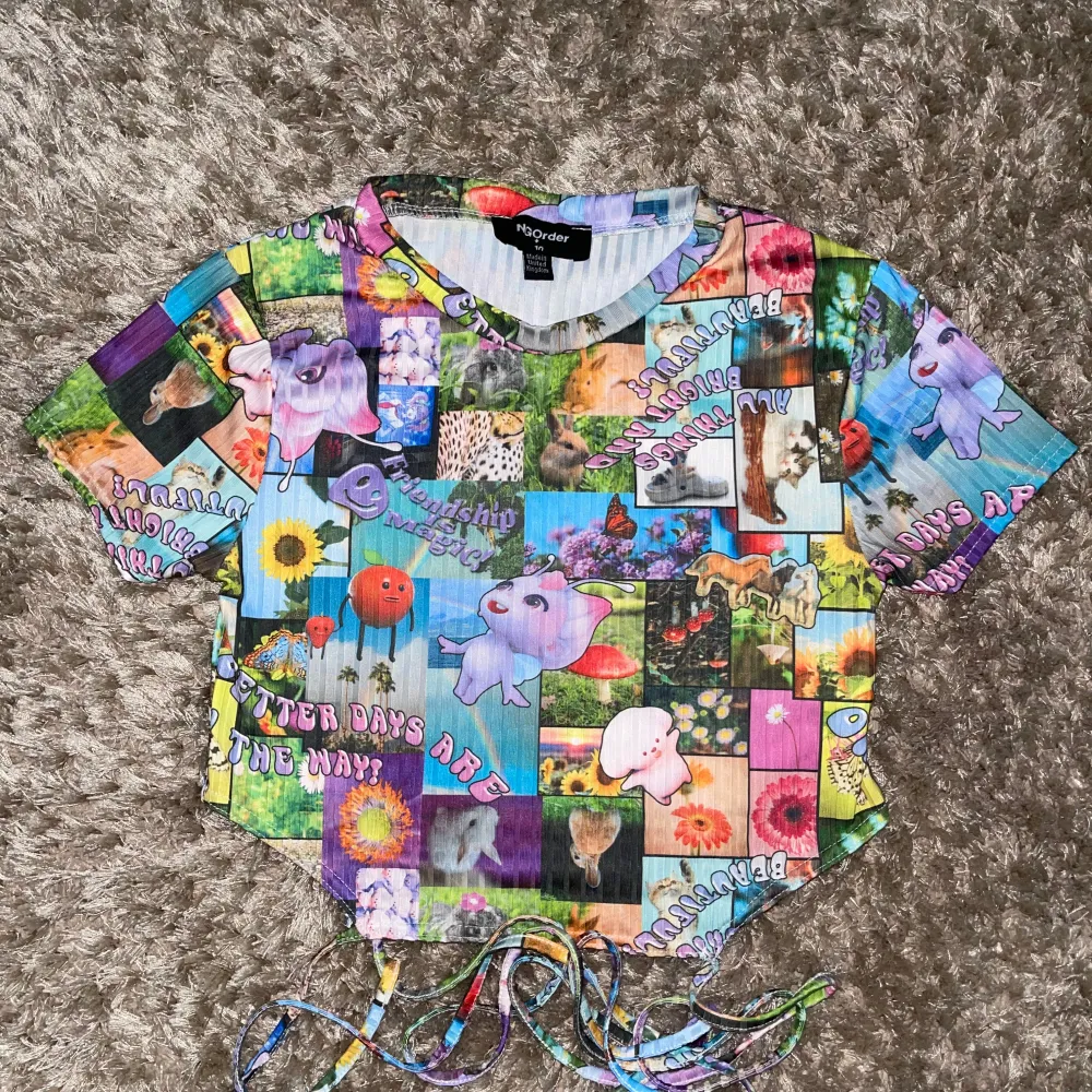 Säljer en supercool och färgglad croppad topp med ett unikt collage-mönster. Toppen har korta ärmar och en snygg knytning i midjan som ger en extra detalj. 🦄🌈 Köpt på zalando från märket NEW girl order för ungefär 400 kr* 🌼 helt  nyskick😇. Toppar.