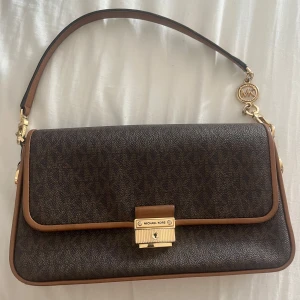 Micheal Kors axelväska  - Säljer en äkta och stilren Michael Kors axelväska i toppskick! Den är köpt av micheal kors butik för 2500kr och har en axelrem för maximal komfort. Perfekt till jobbet eller en utekväll. Äkta låda och påse för väskan medföljer. Kontakta mig för mer info! kvitto finns och bara seriösa köpare tack!