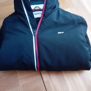Tommy jeans TJM ESSENTIAL PADDED JACKET Strl XS - Snygg och bekväm jacka i mycket bra skick -endast används i ett fåtal gånger. vadderad modell som passar perfekt för höst och mild vinter. Klassisk Tommy -design som funkar både till vardag och fritid 