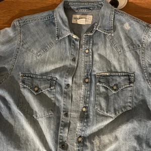 Ralph lauren denim & supply jeansskjorta - Asschysst denim & supply jeansskjorta. Väldigt bra skick. Den har sköna slitningar vid axeln och bröstet. 