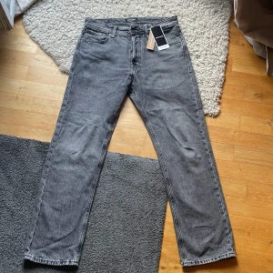 Grå jeans I relaxed Chris Från Jack & Jones   - Säljer ett par grå jeans från Jack & Jones. I passformen Relaxed Chris! De har en klassisk femficksdesign och är i ett mycket bra skick. Bara tvättade en gång och nästan helt nya. Säljer eftersom det blev fel storlek.