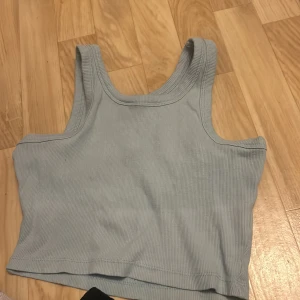 Ljusblå ribbad linnetopp från 157 - Säljer en superfin ljusblå ribbad linnetopp från 157 i storlek XS. Perfekt för sommardagar eller som ett lager under en kofta. Toppen är i mycket bra skick och har en enkel, stilren design. Passar perfekt till både jeans och kjol!