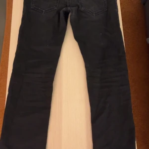 Svarta jeans från Diesel - Säljer ett par svarta Diesel jeans i bra skick. De har en klassisk straight passform. Jeansen är tillverkade i ett stretchigt material för extra komfort. 