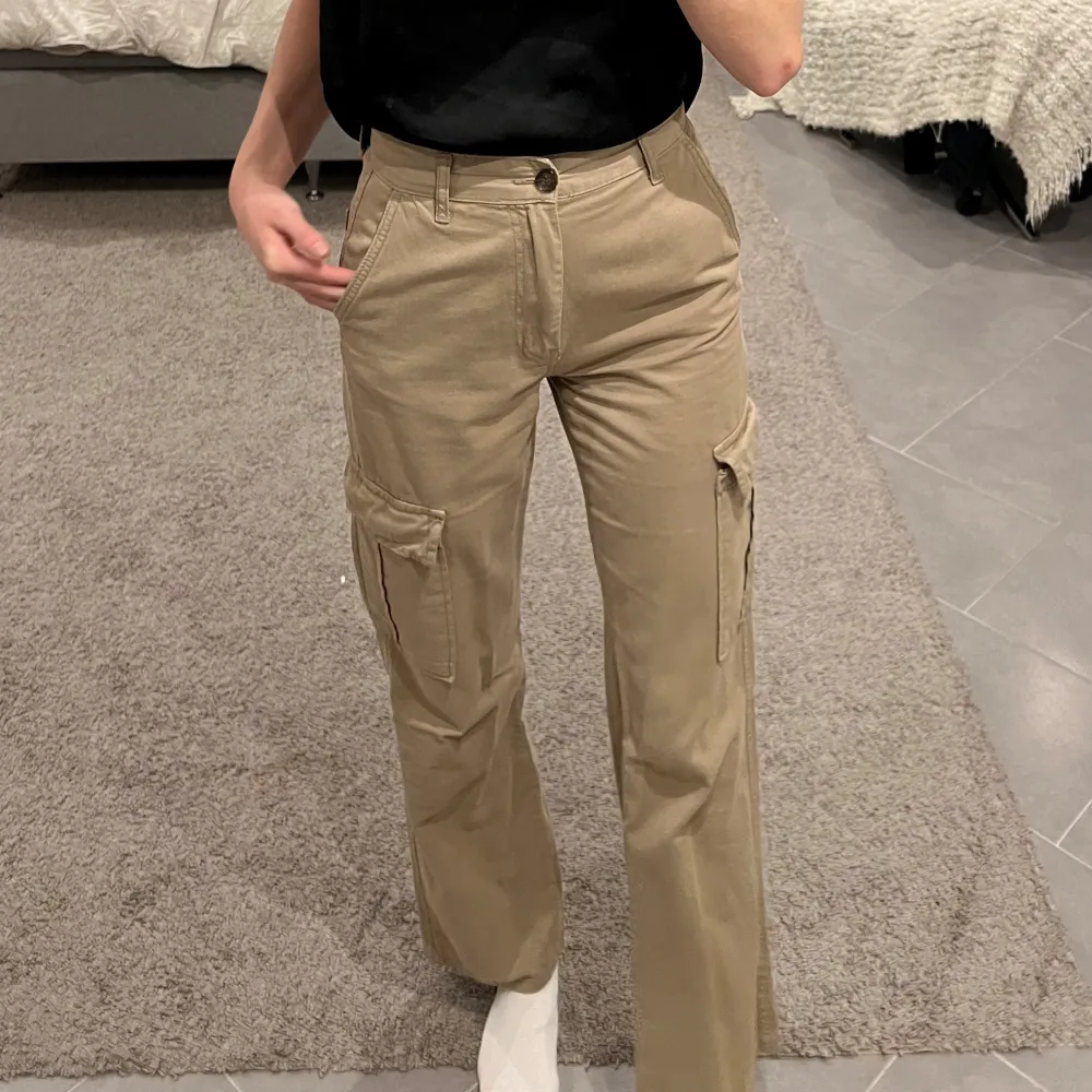 Snygga beige cargopants i mycket bra skick. De har en normal passform och är perfekta för höst och vår. Perfekta för en avslappnad look! Slutsåld på hemsida. Knappt använda!. Jeans & Byxor.