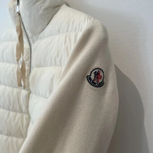 Cardigan moncler  - Säljer en snygg vit cardigan från Moncler i mycket bra skick. Jackan har en dragkedja framtill och Monclers logga på ärmen. Perfekt för kyliga höst- och vårdagar. Den är både stilren och bekväm, med en normal passform.