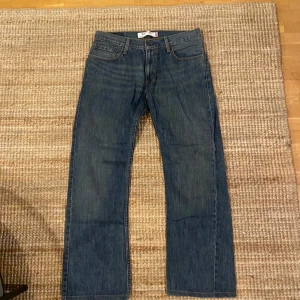 Levi's 527 jeans - Säljer ett par klassiska Levi's 527 jeans i blå denim. De har en bootcut-stil och är i mycket bra skick.