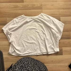 Vit crop topp från Shein - Säljer en vit crop topp från Shein i storlek 4XL. Den är superbekväm och perfekt för en avslappnad stil. Toppen är ärmlös och har en lös passform, vilket gör den idealisk för varma sommardagar. Perfekt att matcha med jeans eller shorts för en casual look.
