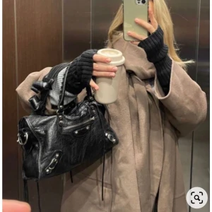 Svart skinnväska med dragkedja - Säljer en snygg svart skinnväska i mycket bra skick. Den har en cool design med dragkedja och nitar som detaljer. 🖤 köpt på plick.