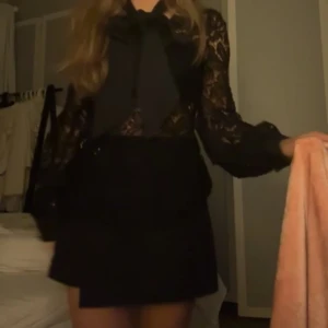 Svart spetstopp med rosett - Snygg svart topp med spetsdetaljer och en stor rosett framtill. Köptes här på plick så vet inte exakt hur många gånger den har använts, men det är i ett jättebra skick💋💋