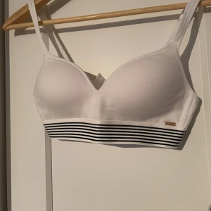 Vit bh från Holly & Whyte - Säljer en stilren vit bh från Holly & Whyte med smala axelband. Justerbara band. Sustainable Choice-kollektion. Perfekt för en bekväm och snygg look. Storlek 75A.🍒✨