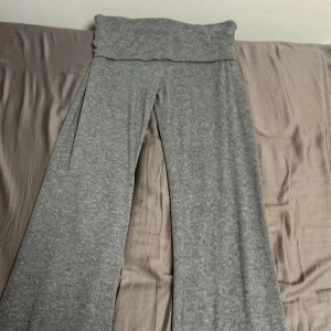 Grå ribbade yoga  pants från Gina Tricot - Snygga grå ribbade byxor från Gina Tricot med en bekväm passform. Byxorna har en bred linning och utsvängda ben, vilket ger en avslappnad stil. Perfekta för en casual look. De är också väldigt mjuka och sköna☺️