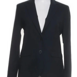 Svart kavaj och kjol från STOCKH LM - Elegant svart kavaj med två knappar och matchande kjol. Perfekt för en stilren look. Kavajen har en klassisk passform och kjolen är knälång.