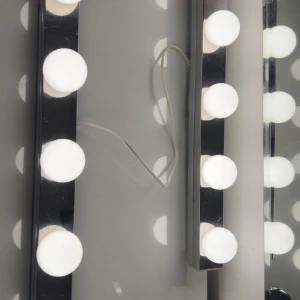 Vägglampa  - Fungerar perfekt. Dom sitter ihop med en sladd i mitten som man lägger bakom sin spegel .Finns i Stockholm om du vill ses och hämta istället.