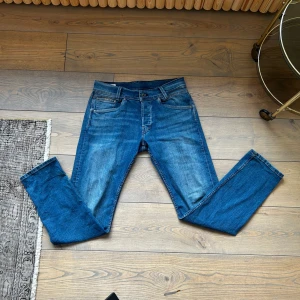 Jeans från Pepe Jeans London - Snygga blå jeansbyxor från Pepe Jeans med klassisk femficksdesign och knappgylf. De har en lätt tvättad look och är perfekta för en avslappnad stil. Märkeslappen i läder baktill ger en extra touch av stil.