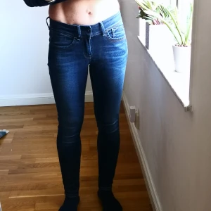 Mörkblå jeans från G-Star Raw modell Lynn - Snygga mörkblå jeans från G-Star RAW, modell Lynn Mid Skinny. De har en tight passform och är midwaist. Perfekta för en stilren look.