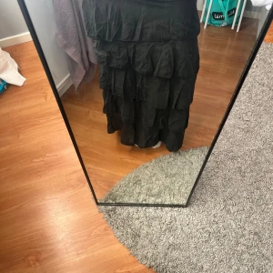 Svart volangkjol - Svart långkjol med flera lager av volanger. Kjolen har en loose passform och är perfekt för en bohemisk stil. Den är tillverkad i ett lätt och luftigt material som ger en fin rörelse när du går. Perfekt att även ha som klänning, 2 outfits i 1 plagg😻