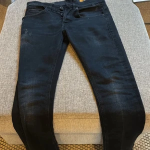 Mörkblå Dondup  jeans - Snygga  jeansbyxor med en tight passform och låg midja. Byxorna har en klassisk femficksdesign och knappar i midjan. Perfekta för en stilren look.