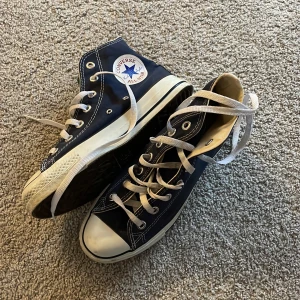 Mörkblåa Converse All Star sneakers - Säljer ett par mörkblåa Converse All Star sneakers med hög snörning och vit tåhätta. 💗