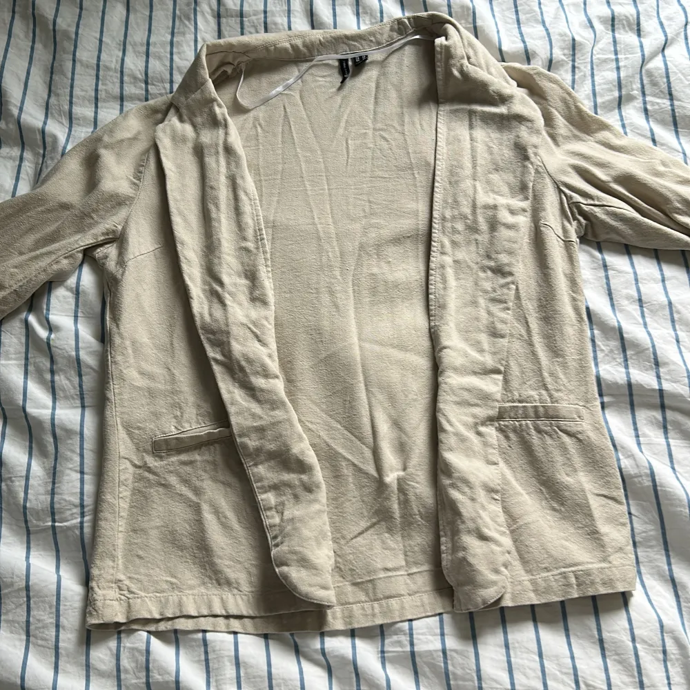 Snygg beige kavaj med kortärmad design och stilrena detaljer. Perfekt för en chic look. Kavajen har en avslappnad passform och är tillverkad i ett lätt material som ger en bekväm känsla 💕❤️🎀. Takit.