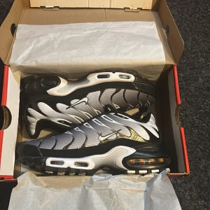 Nike TN i silver och svarta färg - Snygga Nike TNr i en cool kombination av svart och silver. Skorna har en unik design med vågformade detaljer och synlig Air Max-dämpning i sulan. 