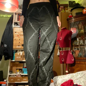 Svarta byxor med taggtrådsmönster - Svarta byxor med taggtrådsmönster i grått. Loose passform och är högmidjade med elastisk midja. Köpte dem online nån gång och har slutat använda dem. 