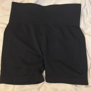 Svarta träningsshorts  - Snygga svarta träningsshorts med elastiskt material för bästa rörlighet. Perfekta för gymmet eller löprundan. De har ej använts och funkar bra att vika ner
