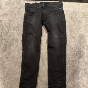 Svarta jeans från Replay - Snygga svarta jeans från Replay med en stilren design. De har en dragkedja och knapp framtill samt klassiska fem fickor. Perfekta för en cool och avslappnad stil.