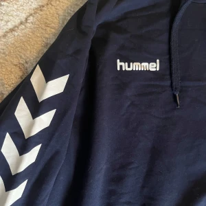 Hummel hoodie - Bekväm hoodie i fint skick. Har några fläckar på framsidan (syns på sista bilden) men de ska nog gå bort i tvätten. Annars är den i så gott som nyskick.  Står storlek 3XL i den, men den sitter snyggt och lite oversized på mig som har M, så mer en L.