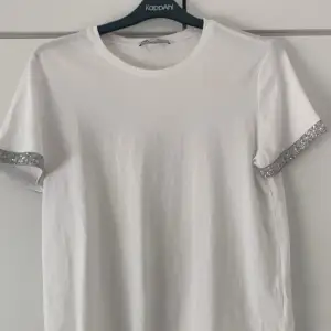 En t-shirt från zara med pärlor detaljer vid ärmarna, köpte från plick men har aldrig använt den💕