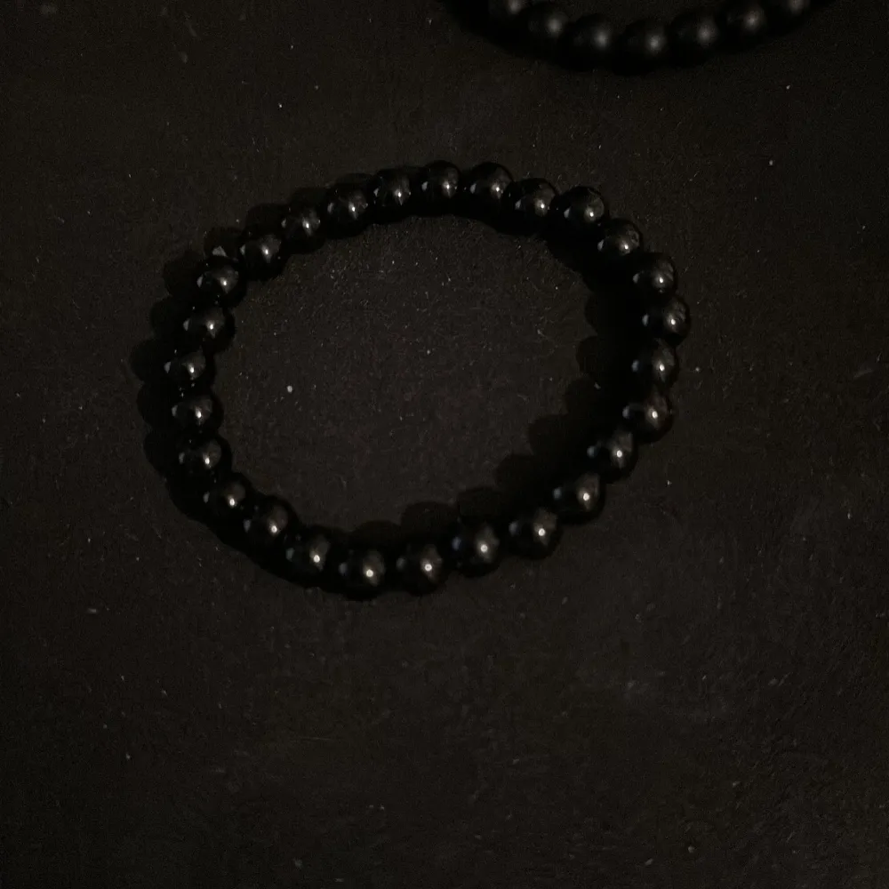 Säljer tre snygga elastiska armband med pärlor. Det ena armbandet har blå och grå pärlor som ger en cool, mystisk look. Det andra armbandet är helt svart och passar perfekt till alla outfits. Båda armbanden är bekväma att bära och lätta att matchamed. Accessoarer.