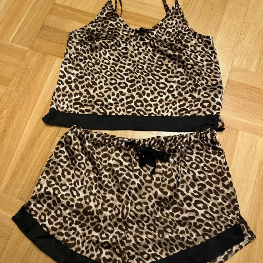 Säljer en superfin leopardmönstrad pyjamas i satin. Setet består av en ärmlös topp med smala reglerbara axelband och matchande shorts. Båda delarna har svarta detaljer vid kanterna. NYTT från Bubbleroom. Storlek M🖤. Övrigt.