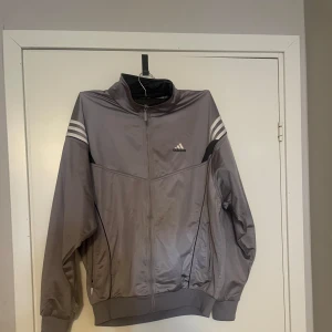 Adidas kofta  - Säljer en grå träningsjacka från Adidas i storlek M. Perfekt för träning eller som en casual vardagskofta. Har användts ett fåtal gånger. Är i ok skick då den är vintage.