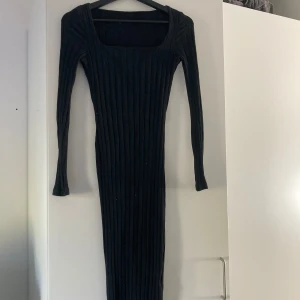 Svart ribbad klänning - Säljer en superfin svart ribbad klänning med lång ärm. Den är tight och har en stilren design som passar perfekt för både höst och vinter. Klänningen är i ett mjukt och stretchigt material som gör den bekväm att bära hela dagen.