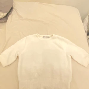 Vit tröja från Zara - Säljer en stilren vit tröja från Zara i storlek S. Perfekt för en minimalistisk look och passar till alla tillfällen. Tröjan har en normal passform och är tillverkad i ett mjukt material för extra komfort. Ett måste i garderoben! 🤍