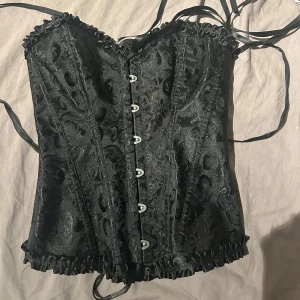 Svart korsett med snörning - Säljer min fina korsett topp aldrig använt då den kom för sent förra helloween och har köpt en annan till helloween nu, helt slutsåld därför priset men pris kan diskuteras!