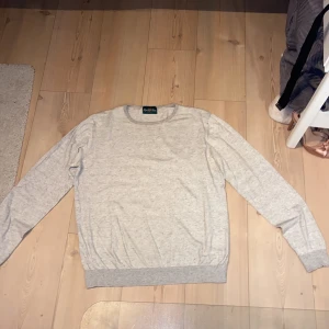 Grå tröja från Alan Paine - 70% cotton 20% silk 10% cachmer Nypris 1500kr. Säljer en stilren och bekväm grå tröja från Alan Paine. Perfekt för både vardag och lite finare tillfällen. Den är i bra skick och redo för en ny ägare! 