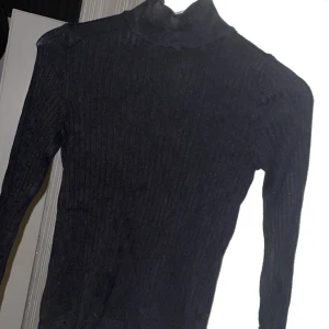 Ribbad tröja - En basic svart, ribbad långärmad tröja med polokrage, knappt använd ifrån ginatricot
