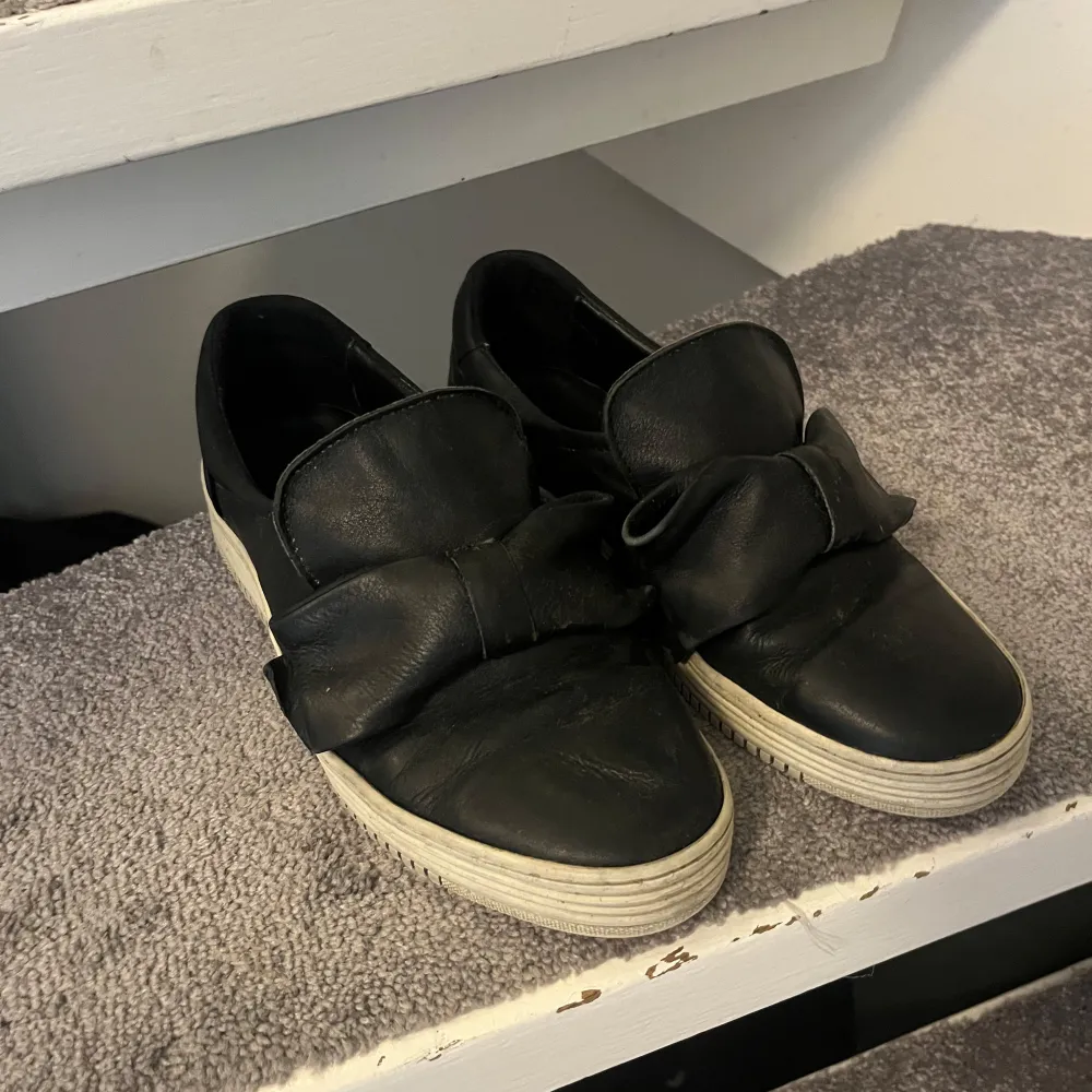 Jätte söta ”slip on” skor med rosett. Fint skick inga defekter bortom lite smuts pga användning. Storlek 38 passar nog 39 också❣️❣️köpta secondhand så vet inte vart dem är från tyvärr. 179 kr vill bli av med dem så buda gärna❣️ . Skor.