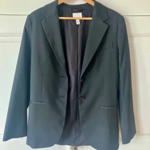 Svart basic kavaj - Kavaj som endast är använd några få gånger. Den är som ny och mkt finare än på bilden. Kommer från HM, storlek XS.   Köparen betalar frakt. 