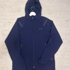 Under armour vindjacka/kofta - En under armour vindjacka/kofta precis som ny, använd 2 gånger bara o inte mer än så för ett bra pris 