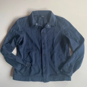 Mörkblå jacka från Selected Homme - Säljer en snygg mörkblå jacka från Selected Homme. Den har en klassisk design med knappar framtill och långa ärmar. Perfekt för både vår och höst. Jackan är i bra skick och passar till många olika stilar. Perfekt för dig som vill ha en stilren look! 💙