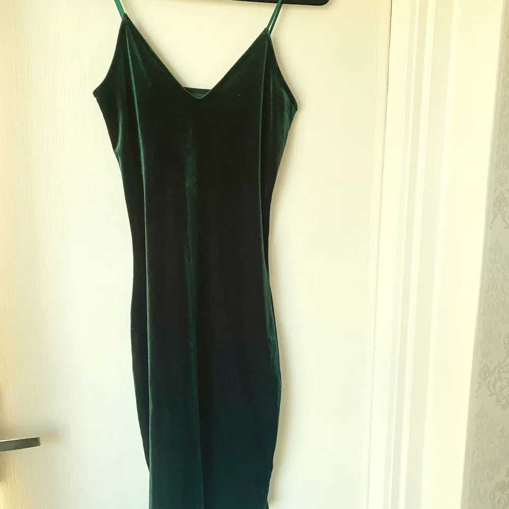 Säljer en elegant grön sammetsklänning från Bik Bok i storlek XS. Klänningen har en v-ringad design med smala axelband och är perfekt för festliga tillfällen. Materialet är mjukt och lyxigt, vilket ger en fin passform och känsla. Passar perfekt till höst- och vinterfester! 💚. Mekot.